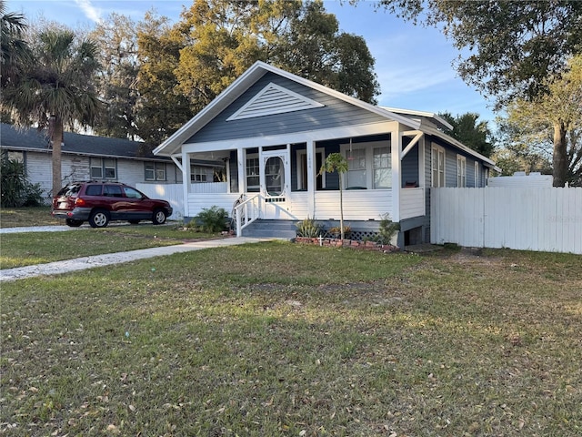 bungalow featuring fence and a front yard