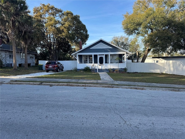 bungalow-style house with a front yard and fence