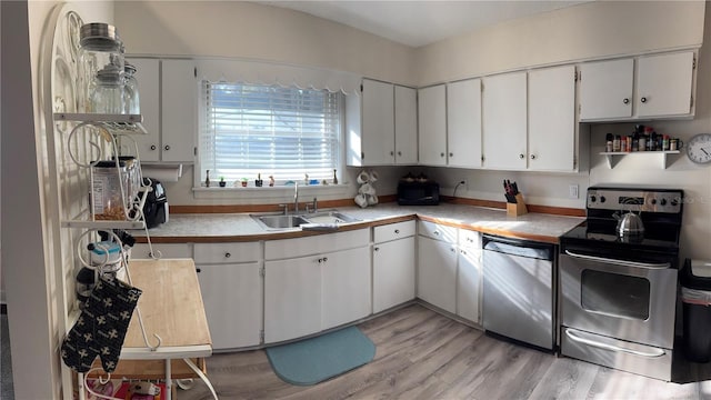 kitchen featuring a sink, stainless steel appliances, light countertops, and white cabinetry