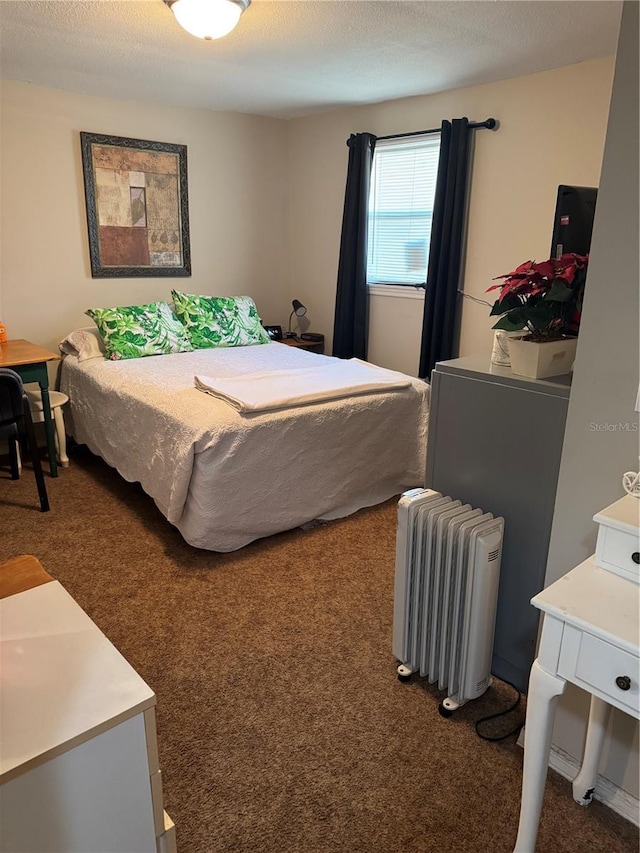 bedroom with radiator, dark colored carpet, and a textured ceiling