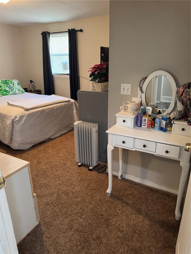 bedroom with radiator heating unit and dark carpet