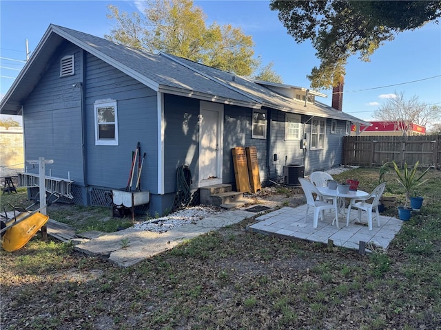 rear view of property featuring entry steps, fence, central AC, and a patio