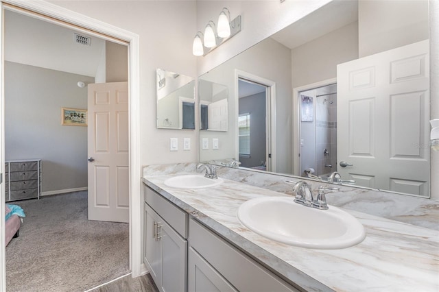 bathroom featuring a shower and double vanity