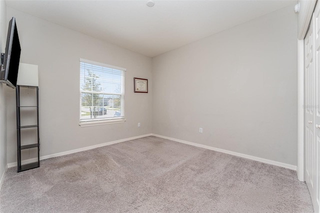 unfurnished bedroom featuring carpet flooring, baseboards, and a closet