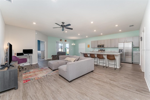 living area featuring light wood-style floors, recessed lighting, a ceiling fan, and baseboards