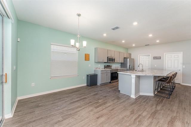 kitchen with stainless steel appliances, a sink, light wood-type flooring, a chandelier, and recessed lighting