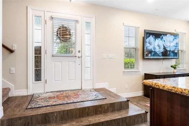 entrance foyer featuring baseboards and stairs