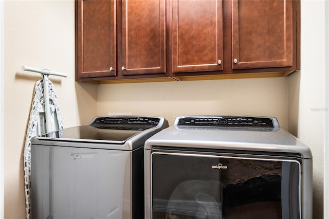 washroom featuring independent washer and dryer and cabinet space