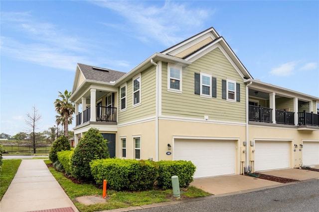 view of side of home with a balcony, an attached garage, and stucco siding