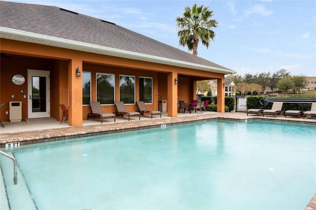 community pool with fence and a patio