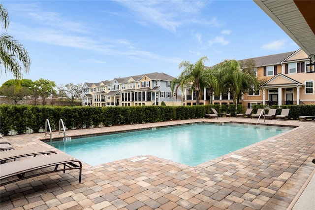 community pool with a patio and a residential view