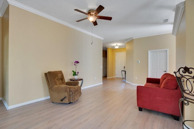 living area featuring visible vents, light wood-style flooring, ornamental molding, ceiling fan, and baseboards