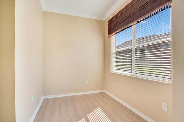 unfurnished room featuring ornamental molding, light wood-style flooring, and baseboards