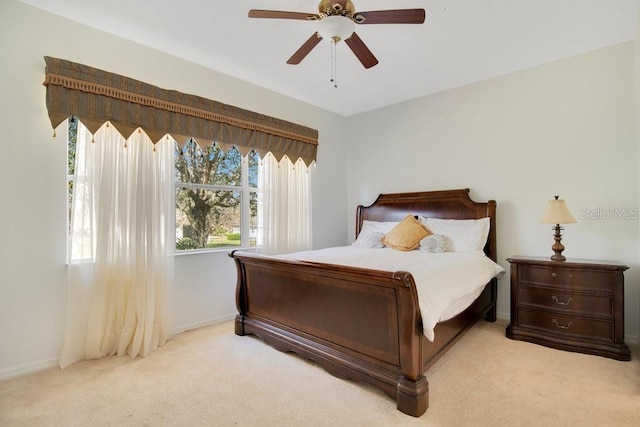 bedroom featuring light carpet, baseboards, and a ceiling fan