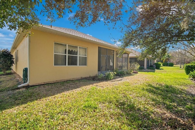 rear view of property with a yard and stucco siding