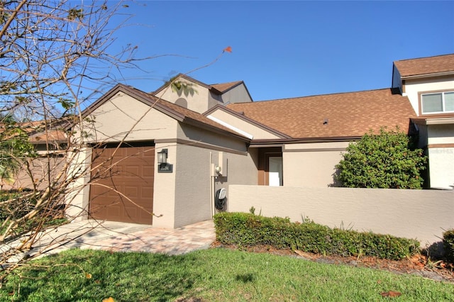 view of front of home with a shingled roof and stucco siding