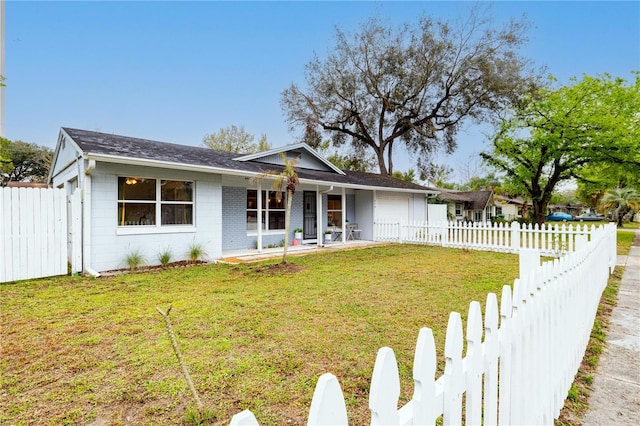 single story home with a garage, a front lawn, fence private yard, and brick siding