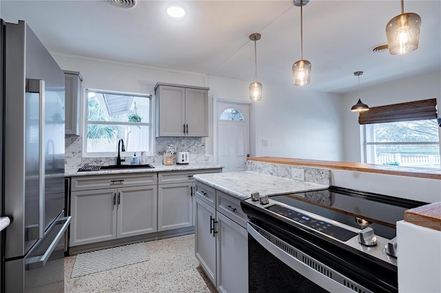 kitchen with plenty of natural light, electric stove, freestanding refrigerator, gray cabinets, and a sink