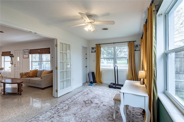 sitting room featuring speckled floor, a ceiling fan, visible vents, and baseboards