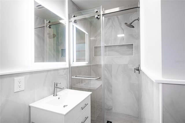 full bath featuring vanity and a marble finish shower