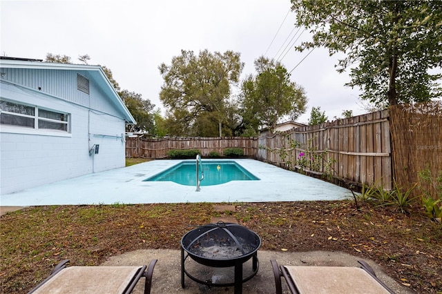 view of pool featuring a fenced backyard, a fire pit, a fenced in pool, and a patio