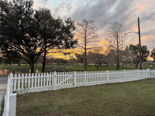 yard at dusk featuring fence private yard