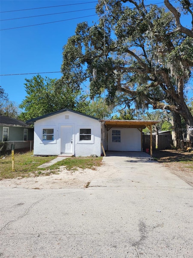 view of front of home with a carport, fence, and driveway