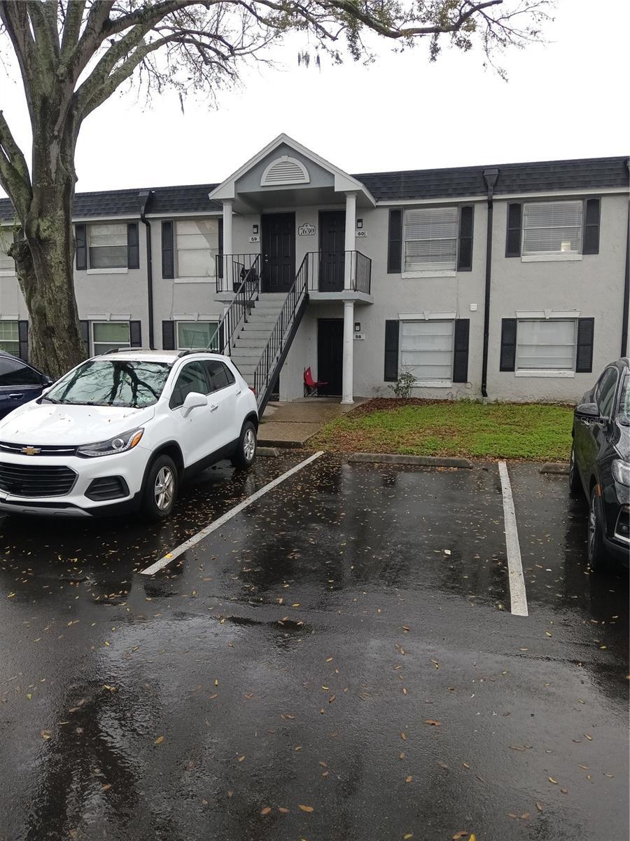 7630 Forest City Rd 059 Aka Unit G, Orlando, FL 32810 - view of front of home with uncovered parking, stairway, and stucco siding