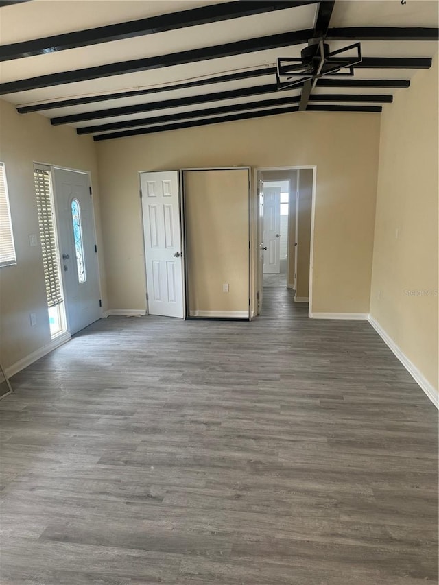 interior space featuring baseboards, wood finished floors, and beamed ceiling