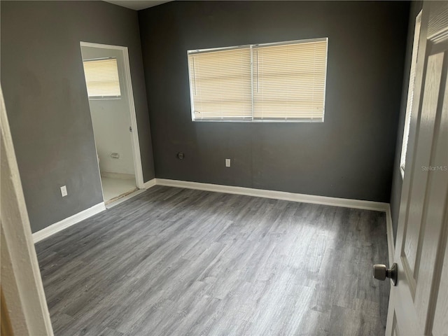 unfurnished bedroom featuring wood finished floors and baseboards