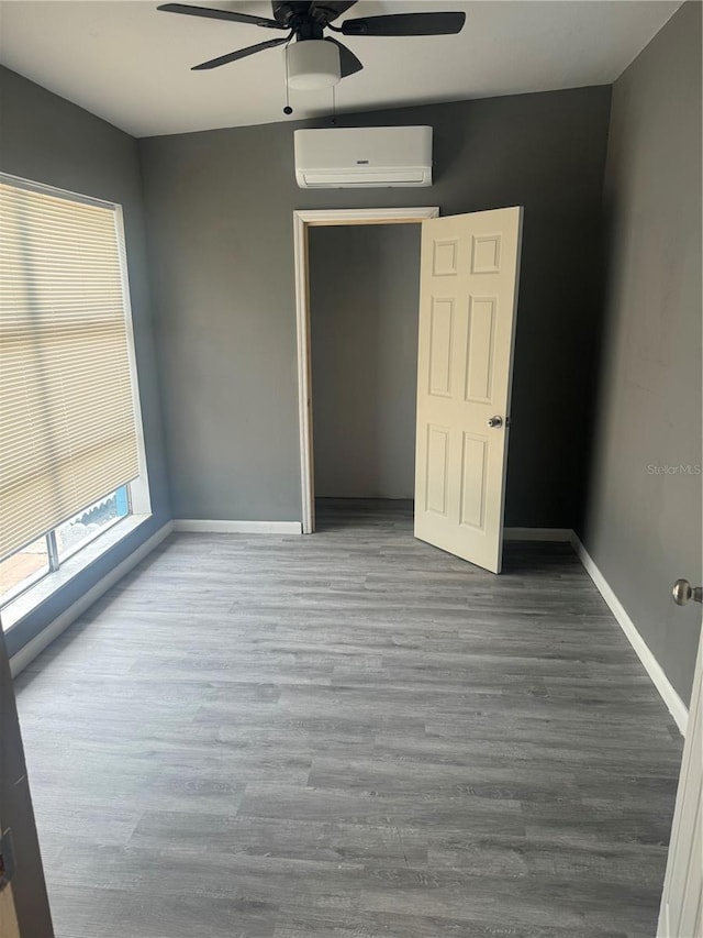 1907 Rockwell Rd, Orlando, FL 32808 - unfurnished bedroom featuring baseboards, a ceiling fan, a wall unit AC, and wood finished floors