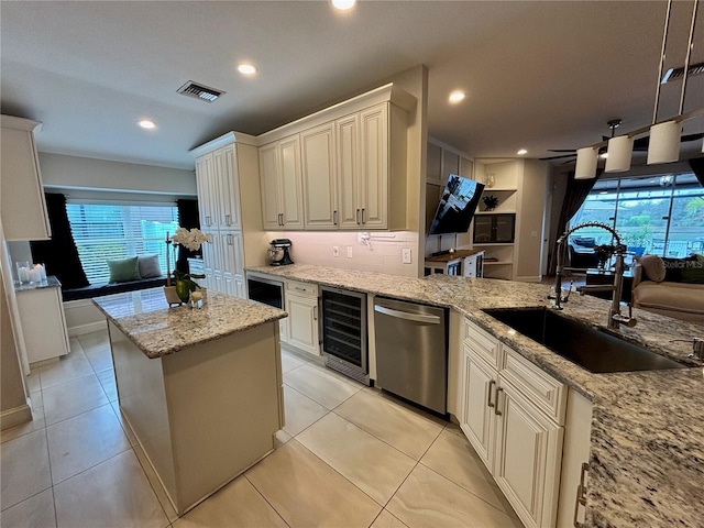 kitchen with beverage cooler, visible vents, light stone counters, stainless steel dishwasher, and a sink