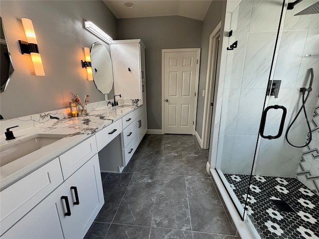 full bathroom featuring double vanity, a shower stall, a sink, and lofted ceiling