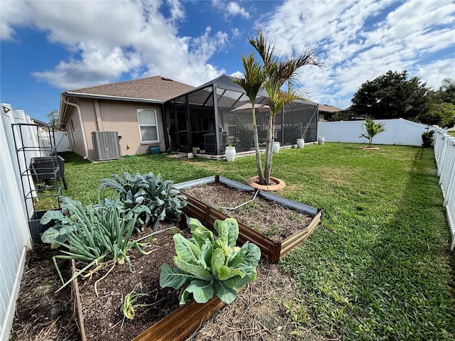 view of yard featuring central AC unit, a fenced backyard, a lanai, and a garden