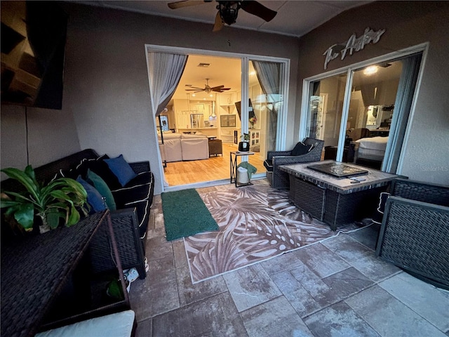 view of patio / terrace with a fire pit and a ceiling fan