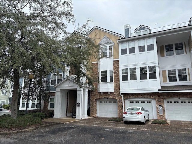 multi unit property featuring a garage and stucco siding