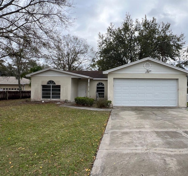 ranch-style house featuring stucco siding, an attached garage, fence, driveway, and a front lawn