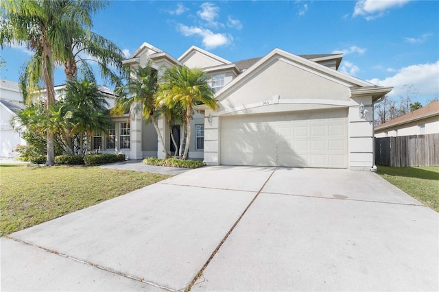 view of front of home featuring a garage, driveway, fence, a front lawn, and stucco siding