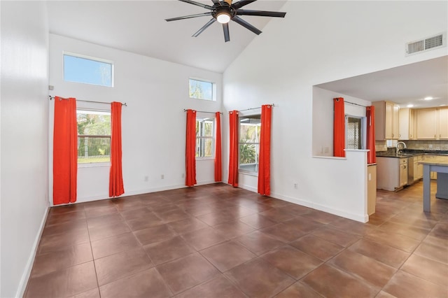 spare room featuring a healthy amount of sunlight, high vaulted ceiling, ceiling fan, and visible vents