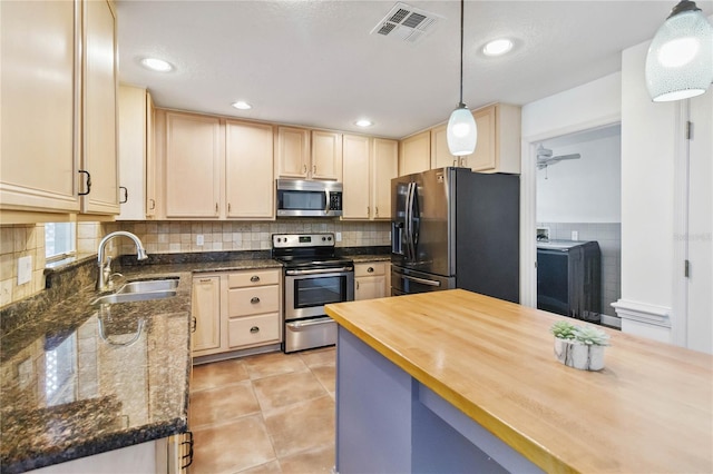 kitchen featuring wood counters, a sink, visible vents, appliances with stainless steel finishes, and pendant lighting