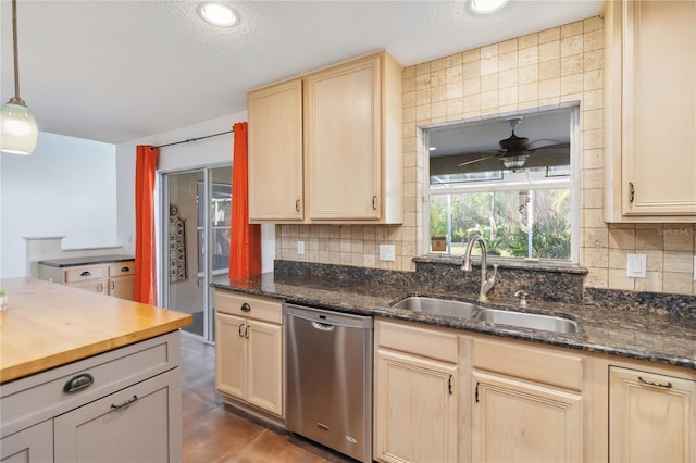 kitchen with light brown cabinets, stainless steel dishwasher, a sink, and decorative backsplash