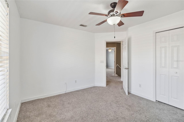 unfurnished bedroom with carpet floors, a closet, visible vents, and baseboards