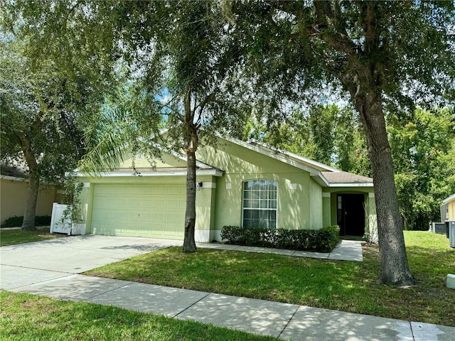 single story home with a garage, concrete driveway, a front lawn, and stucco siding