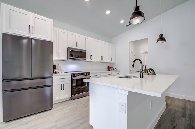 kitchen with an island with sink, white cabinetry, appliances with stainless steel finishes, and a sink