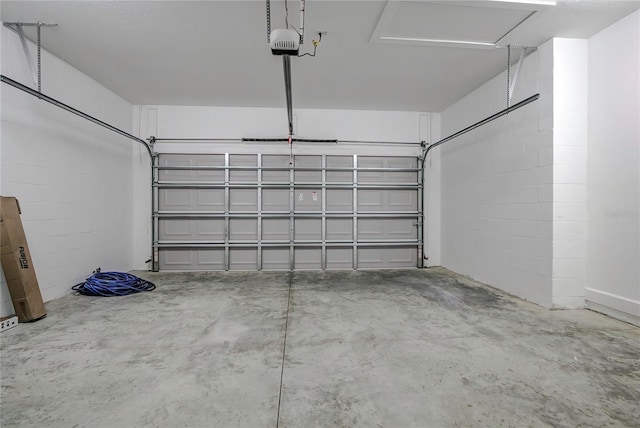 garage with concrete block wall and a garage door opener