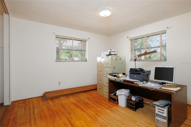 home office featuring light wood-style floors, plenty of natural light, and baseboards