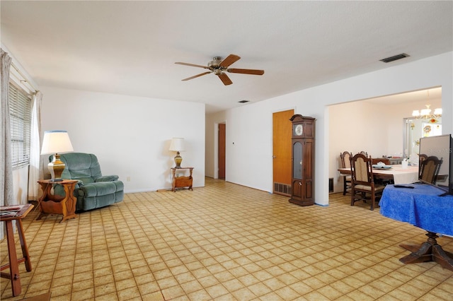 sitting room with visible vents, light floors, and ceiling fan with notable chandelier