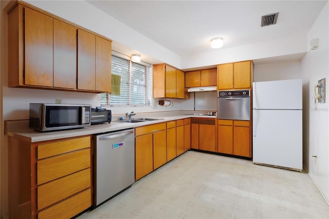 kitchen featuring stainless steel appliances, visible vents, light countertops, brown cabinets, and light floors