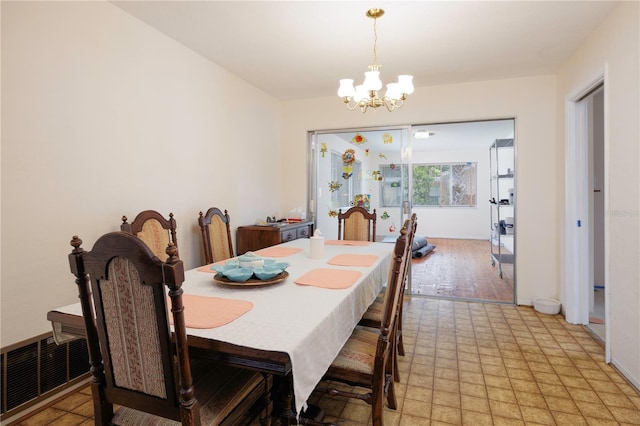 dining space with light floors, visible vents, and a notable chandelier