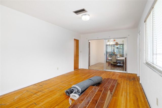 unfurnished bedroom featuring visible vents, a closet, and light wood-style flooring